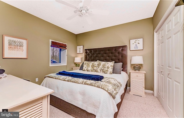 carpeted bedroom with ceiling fan, a textured ceiling, and a closet