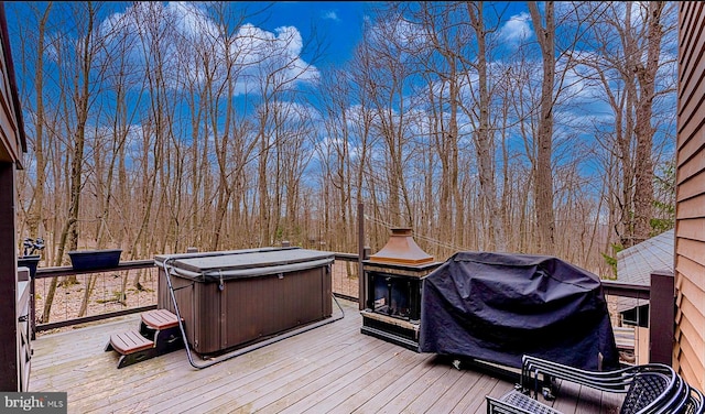 deck with grilling area and a hot tub