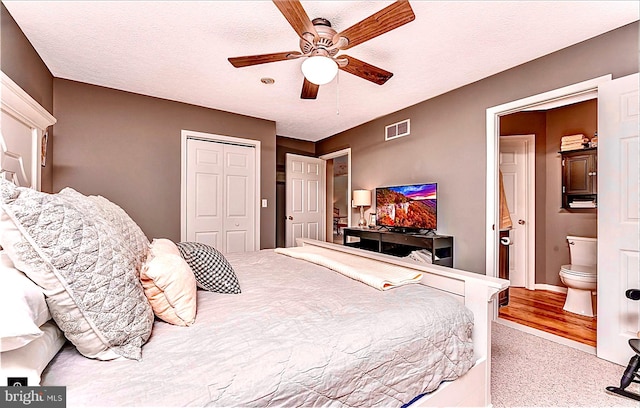 bedroom with connected bathroom, ceiling fan, light carpet, a textured ceiling, and a closet