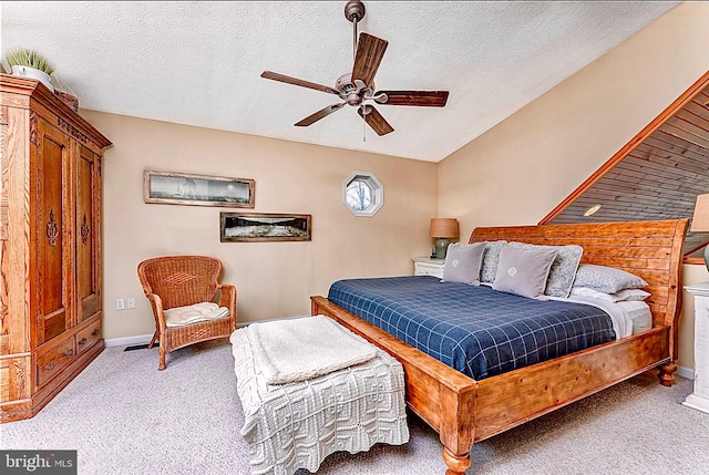 carpeted bedroom featuring ceiling fan and a textured ceiling