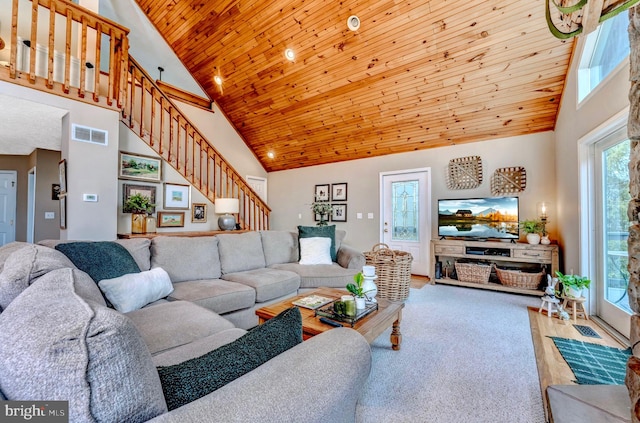 carpeted living room with high vaulted ceiling and wooden ceiling