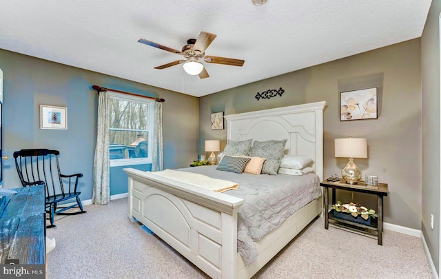 bedroom featuring ceiling fan, a textured ceiling, and light carpet