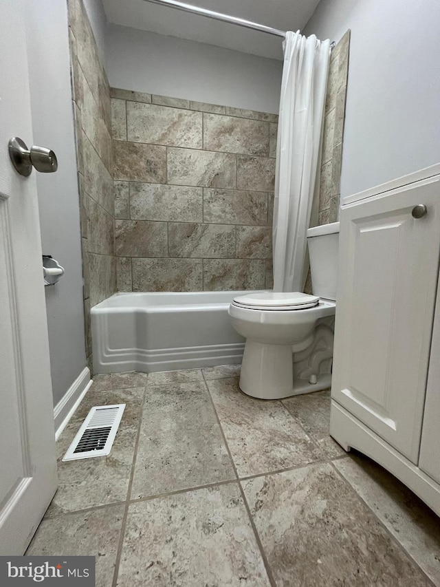 bathroom featuring shower / bath combo with shower curtain, toilet, and tile flooring