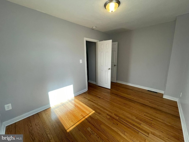 spare room with wood-type flooring