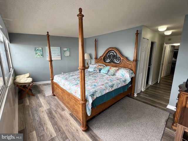 bedroom featuring a textured ceiling and dark hardwood / wood-style floors