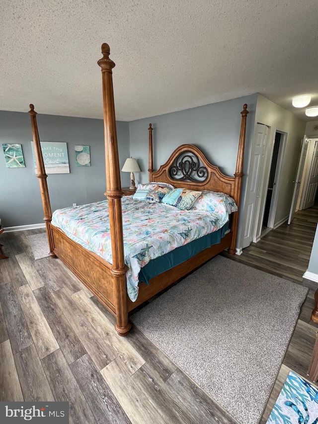 bedroom featuring dark wood-type flooring and a textured ceiling