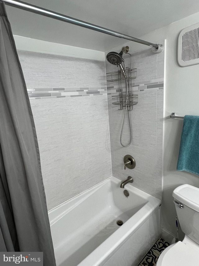 bathroom featuring shower / bath combination with curtain and toilet