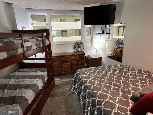 bedroom with a textured ceiling and dark wood-type flooring