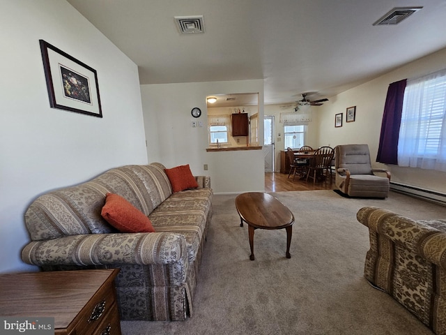 living room featuring ceiling fan, carpet, and baseboard heating