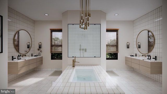 bathroom with tile walls, a relaxing tiled bath, and sink