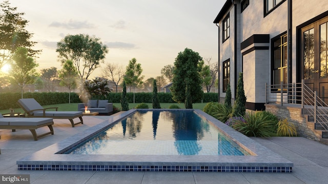 pool at dusk featuring a patio area