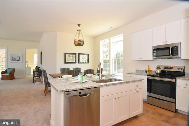 kitchen featuring light colored carpet, white cabinetry, stainless steel appliances, pendant lighting, and sink