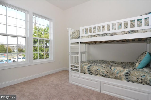 unfurnished bedroom with light colored carpet and multiple windows