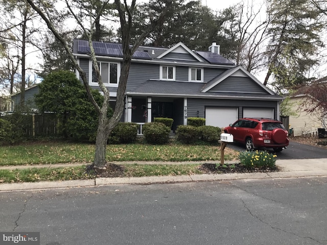 view of front facade with solar panels, a front lawn, and a garage