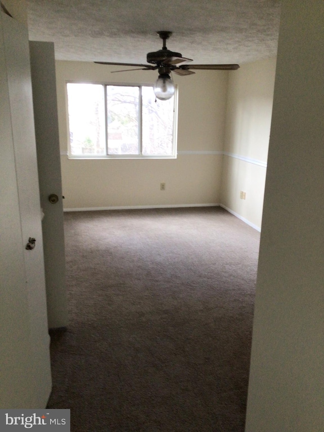 carpeted empty room with ceiling fan and a textured ceiling