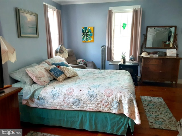 bedroom with multiple windows and hardwood / wood-style flooring