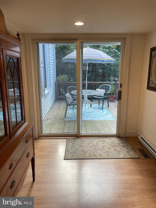 doorway to outside featuring a wealth of natural light and light hardwood / wood-style floors