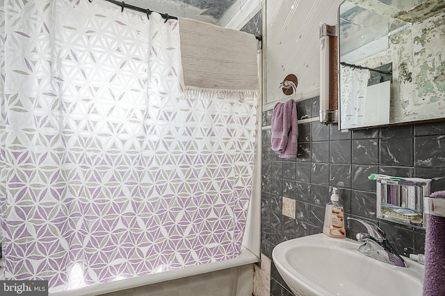 bathroom with tile flooring, sink, and tile walls