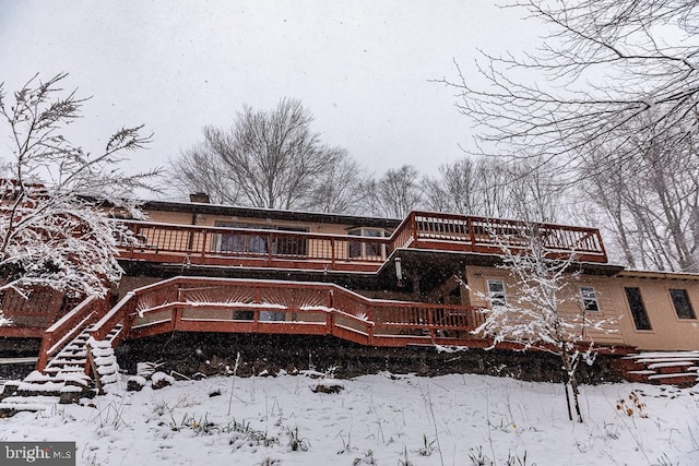 snow covered house with a deck