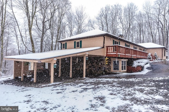 snow covered property with a wooden deck