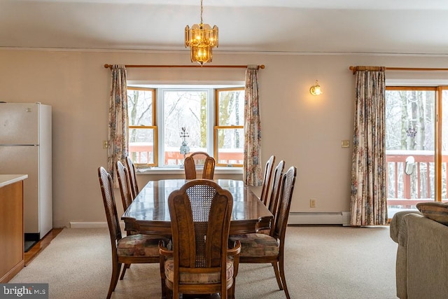 carpeted dining room with an inviting chandelier, baseboard heating, and a wealth of natural light