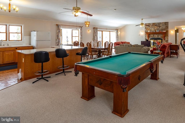 game room featuring light carpet, a healthy amount of sunlight, sink, and a fireplace