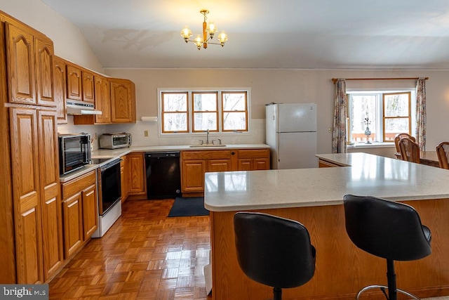 kitchen featuring sink, lofted ceiling, black appliances, and a wealth of natural light