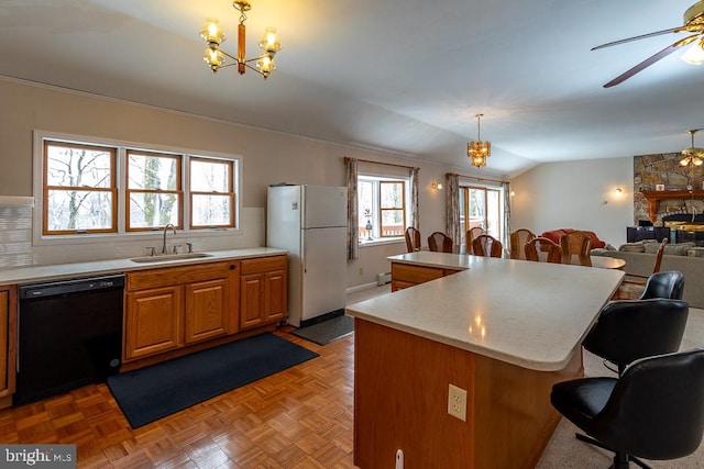 kitchen featuring lofted ceiling, black dishwasher, hanging light fixtures, plenty of natural light, and white fridge