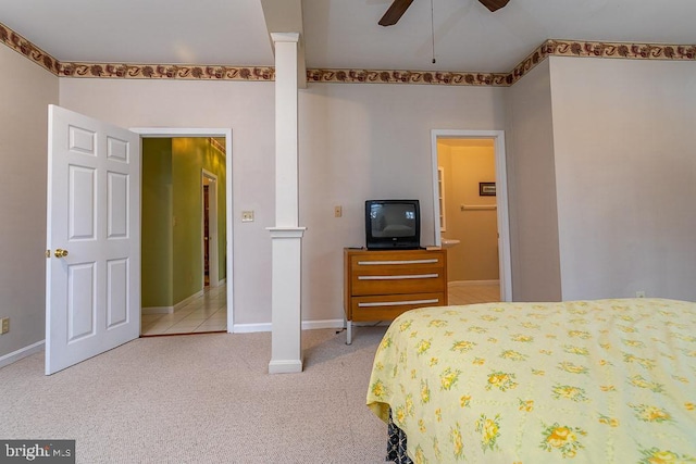 carpeted bedroom with ensuite bathroom and ceiling fan