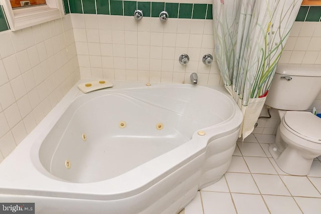 bathroom featuring tile walls, a bath, toilet, and tile patterned flooring