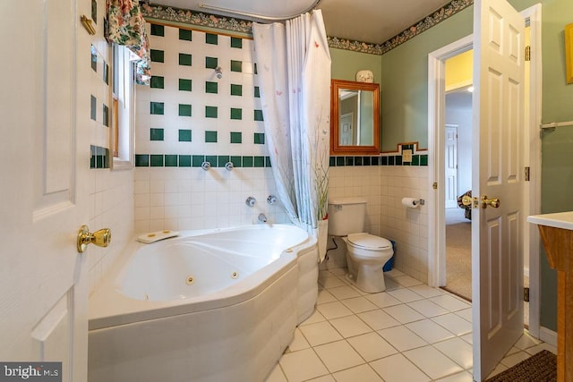 bathroom featuring toilet, a tub to relax in, tile walls, and tile patterned flooring