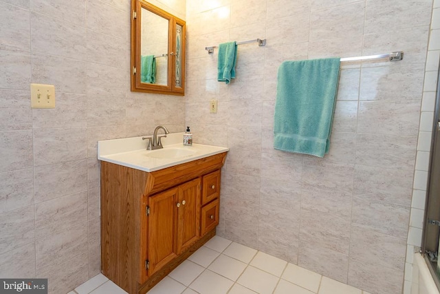 bathroom with tile walls, vanity, and enclosed tub / shower combo