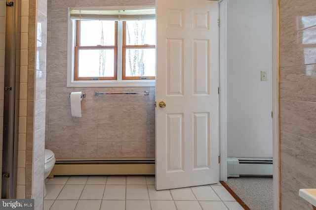 bathroom featuring toilet, a baseboard heating unit, and tile patterned flooring