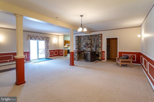 interior space with ornamental molding, light carpet, and a wood stove