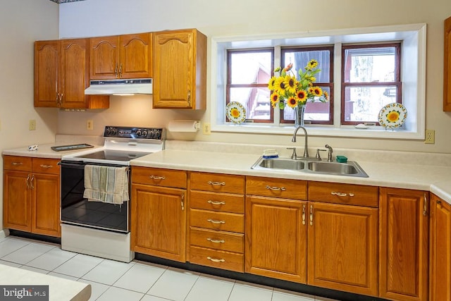 kitchen featuring white electric range, sink, plenty of natural light, and light tile patterned floors