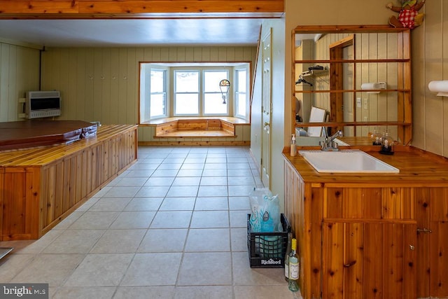 kitchen featuring sink, heating unit, and light tile patterned floors