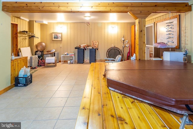 rec room with wood walls and light tile patterned floors