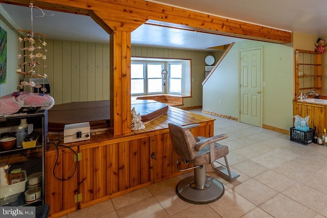 kitchen featuring wood walls, light tile patterned flooring, and sink