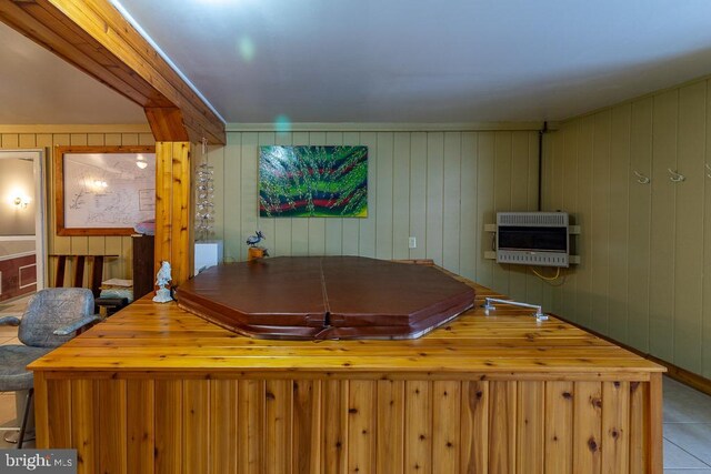 rec room with light tile patterned flooring, wooden walls, and heating unit