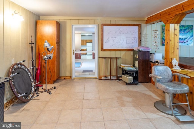 interior space featuring wood walls and light tile patterned floors