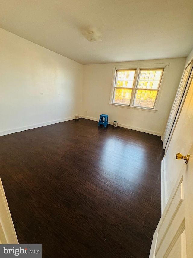 unfurnished room featuring dark hardwood / wood-style flooring