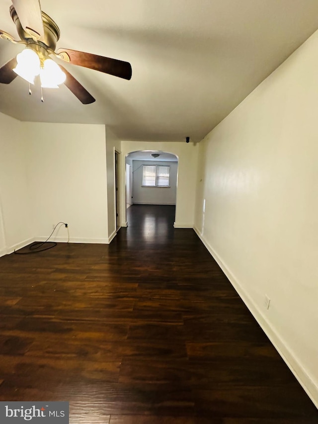 empty room featuring ceiling fan and dark wood-type flooring