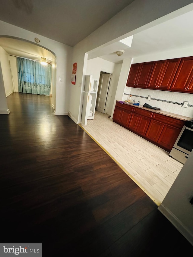 interior space featuring stove, tasteful backsplash, and light hardwood / wood-style flooring