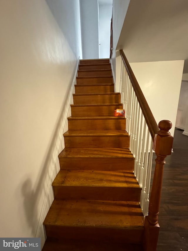 staircase with dark wood-type flooring