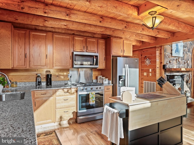 kitchen featuring appliances with stainless steel finishes, light wood-type flooring, sink, beam ceiling, and wooden ceiling