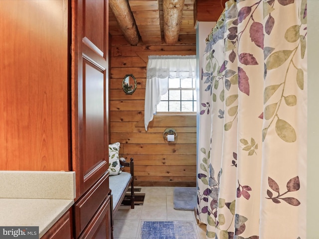 bathroom featuring tile patterned floors, wooden walls, and wood ceiling