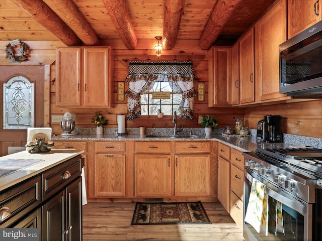 kitchen with sink, beamed ceiling, light hardwood / wood-style floors, wood ceiling, and stainless steel appliances