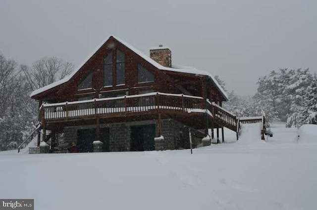 snow covered house featuring a wooden deck