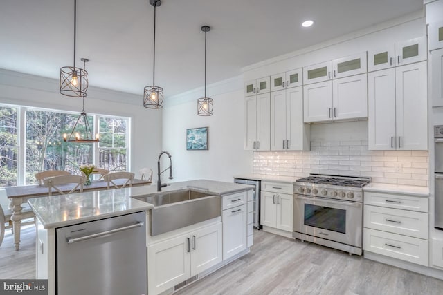 kitchen featuring sink, crown molding, white cabinetry, appliances with stainless steel finishes, and decorative light fixtures