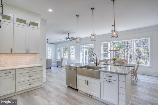 kitchen featuring sink, decorative light fixtures, a kitchen island with sink, white cabinets, and dishwasher